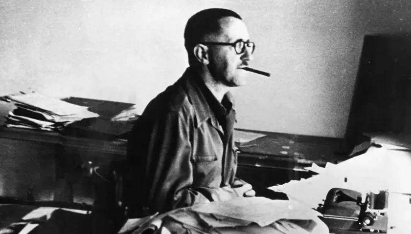 Bertolt Brecht, mit Brille und Zigarre, am Schreibtisch. Er starb 1956.