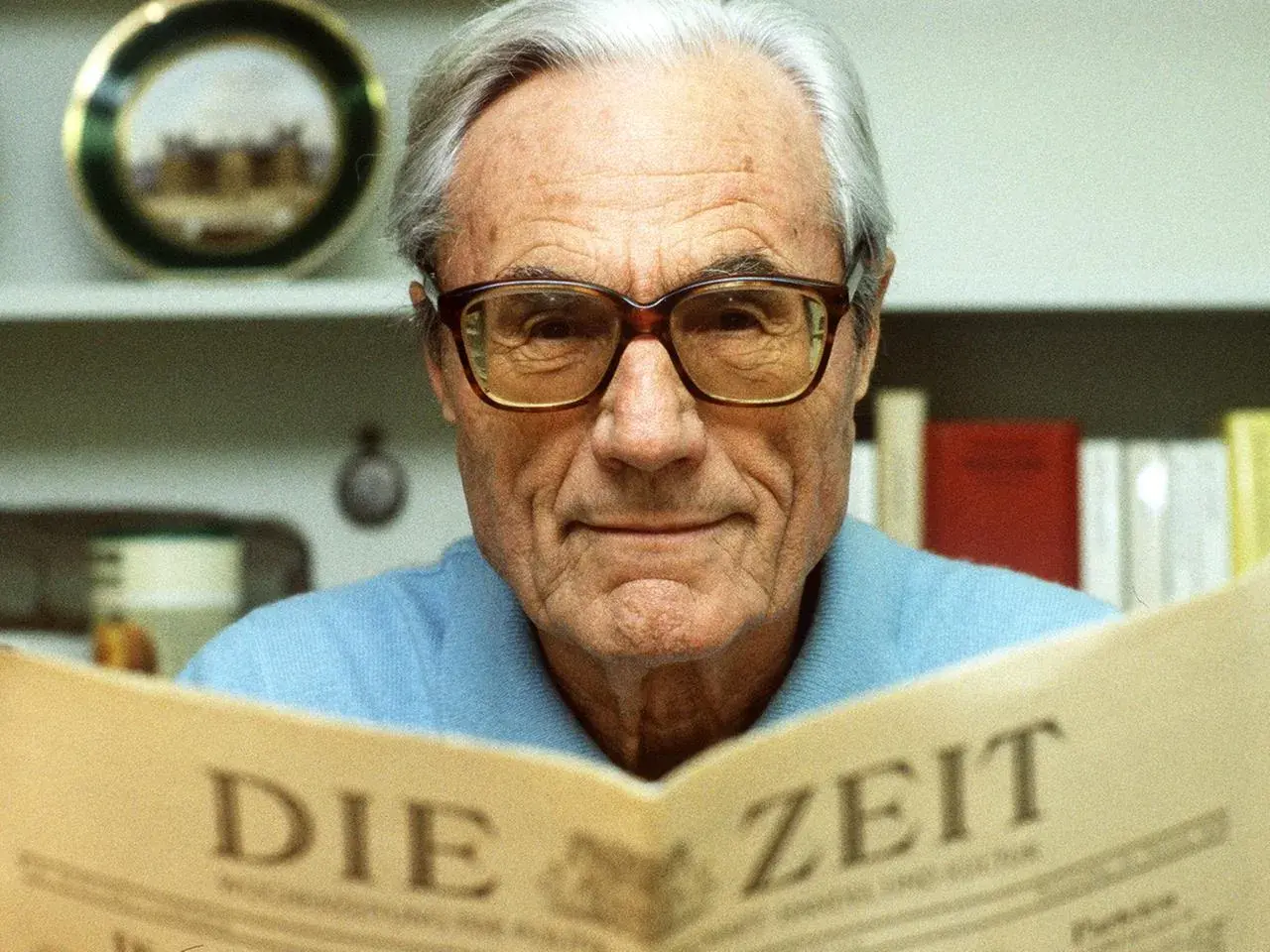 Gerd Bucerius, mit Brille und einem Lächeln, liest die Zeitung "DIE ZEIT".