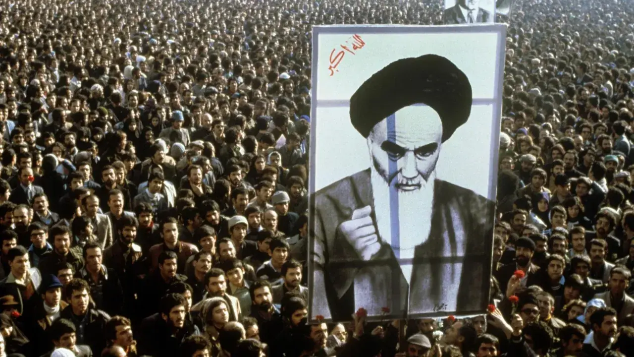 Massen jubeln bei der islamischen Revolution 1979 in Iran, ein riesiges Porträt von Ayatollah Khomeini wird hochgehalten.