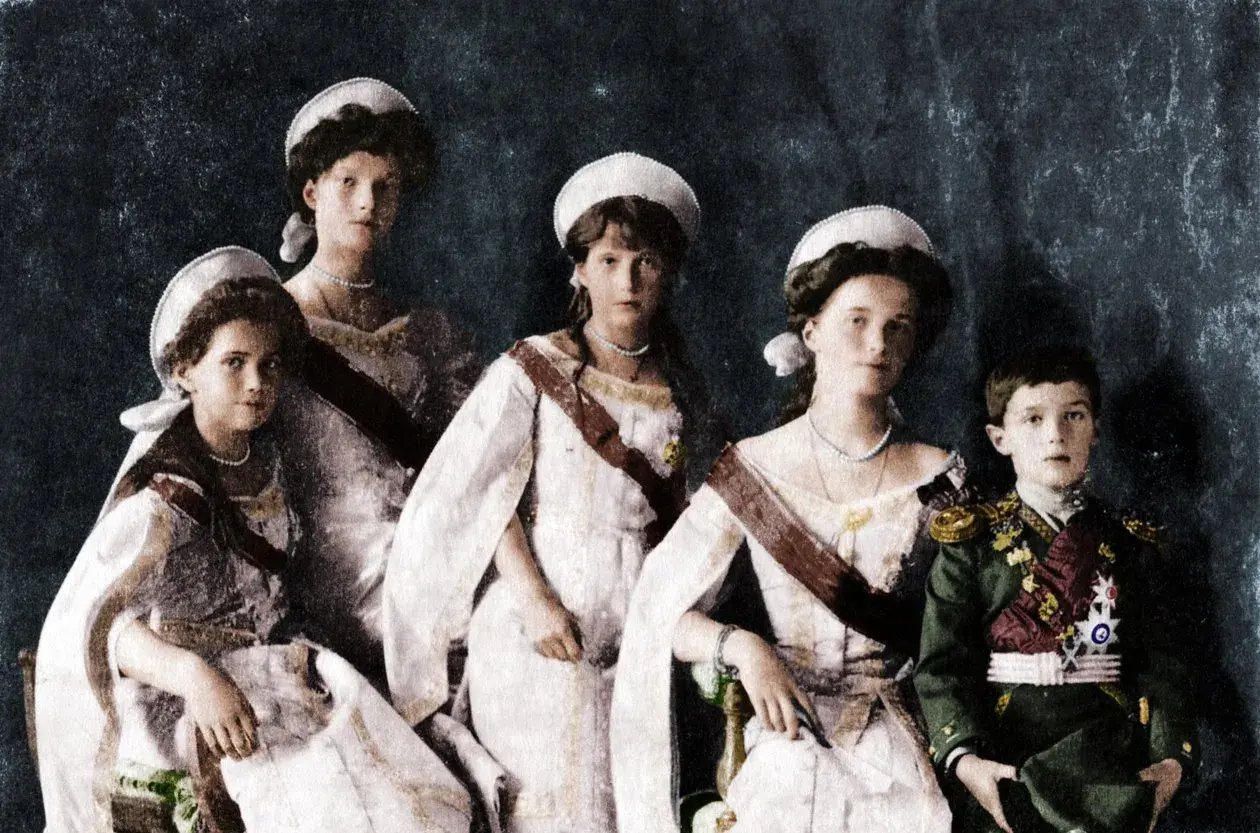 Die Kinder von Nikolaus II. posieren in festlicher Kleidung. Vier Mädchen in weißen Kleidern und ein Junge in Uniform.