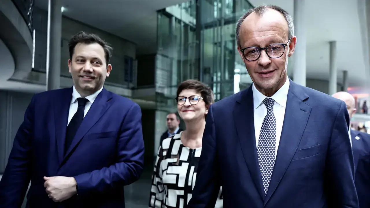 Drei Politiker, die über Koalitionsparteien sprechen, gehen durch einen modernen Gebäudekomplex.