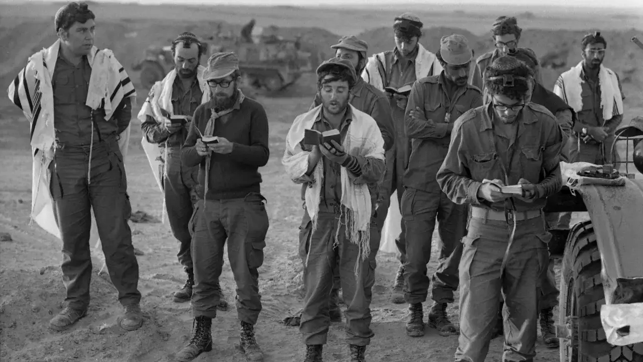 Soldaten beten w&auml;hrend des Jom-Kippur-Krieges mit Gebetsschals und B&uuml;chern.