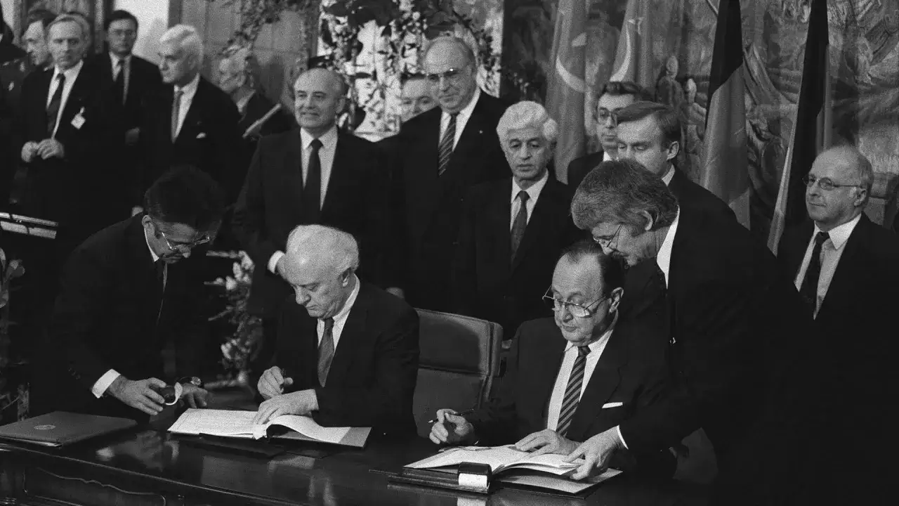 Männer unterzeichnen Dokumente. Die Frage, ob Deutschland ein besetztes Land ist, wird hier durch die Anwesenheit von Gorbatschow und Kohl thematisiert.