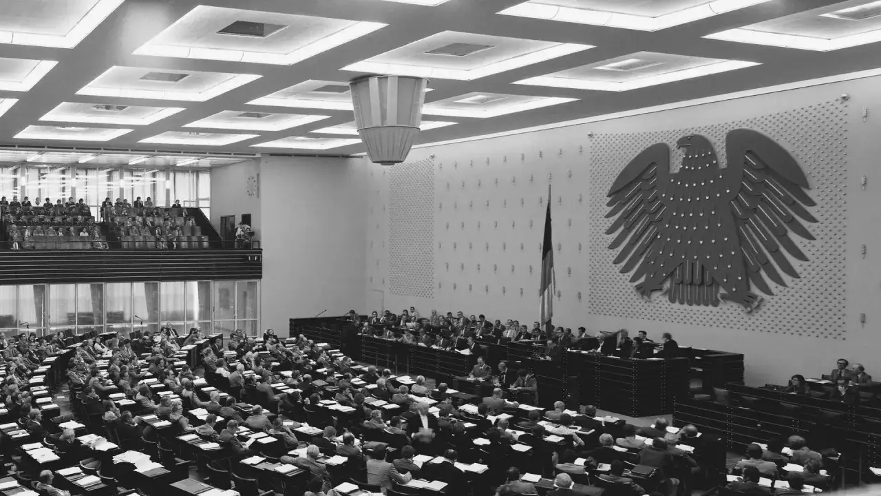 Plenarsaal mit vielen Abgeordneten, dem Bundesadler und einer Fahne. Franz Josef Strauß könnte hier eine Rede halten.