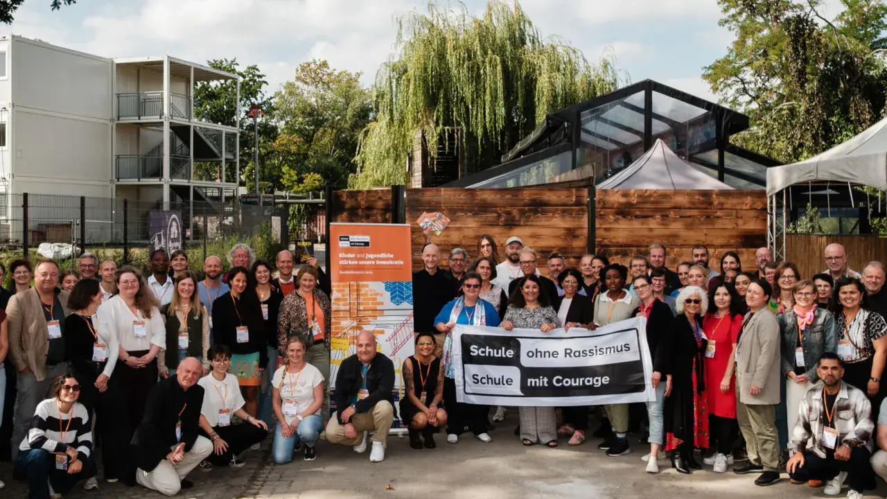 Eine Gruppe von Menschen hält ein Banner mit der Aufschrift 